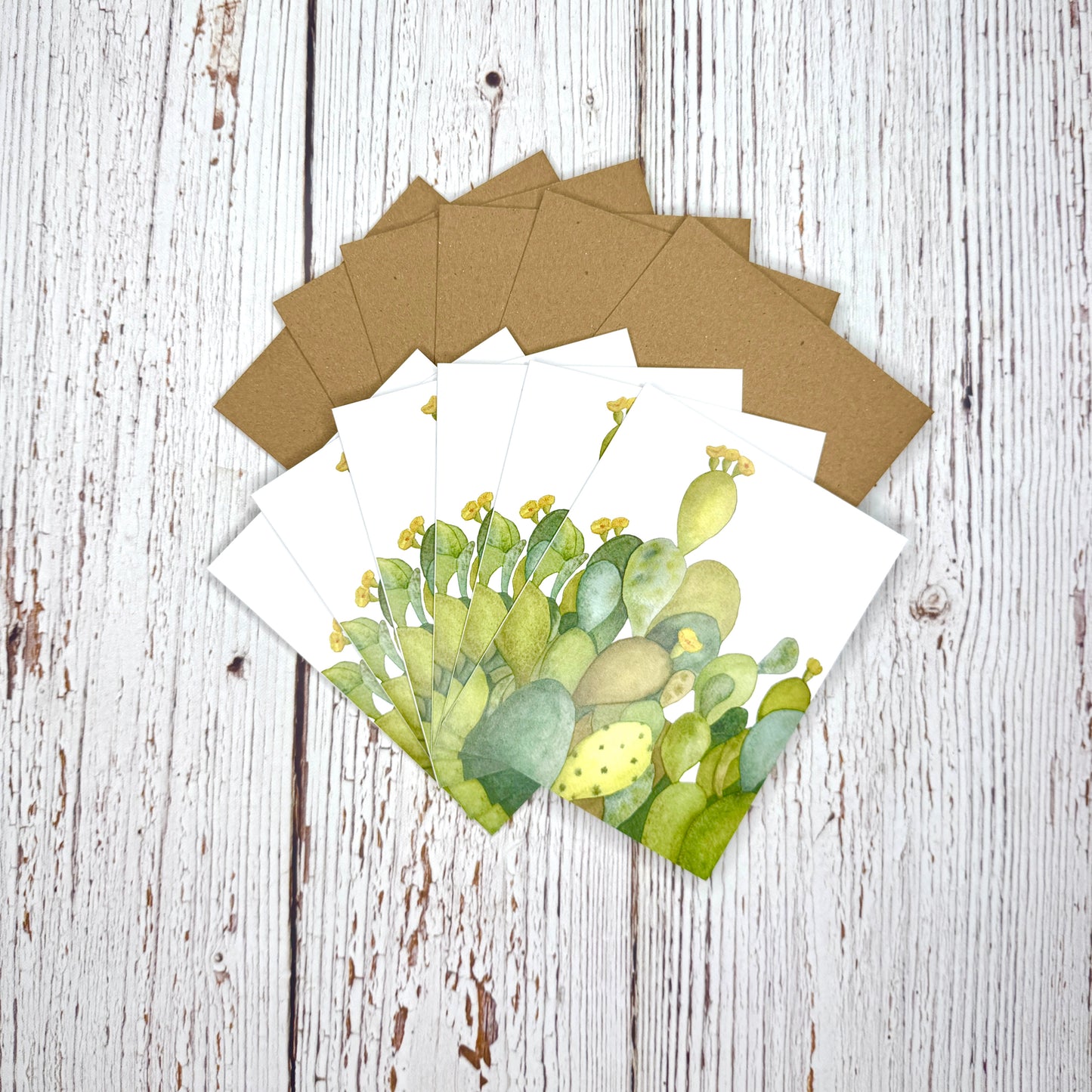 Set of greeting cards with cactus design on a wooden surface
